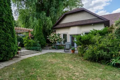 a house with a garden and a patio at 4 Bedroom Stoney Creek Nature Oasis Sauna, Games & Luxury Comfort in Hamilton
