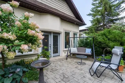 a patio with a chair and a swing at 4 Bedroom Stoney Creek Nature Oasis Sauna, Games & Luxury Comfort in Hamilton