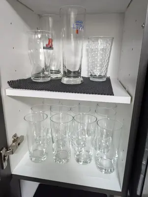 a row of empty glasses sitting on a shelf at Entire Home in Niagara Region, 6 bedrooms, 5 baths with a game room, arcades in Thorold