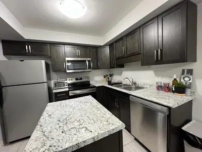 a kitchen with stainless steel appliances and wooden cabinets at Entire Home in Niagara Region, 6 bedrooms, 5 baths with a game room, arcades in Thorold