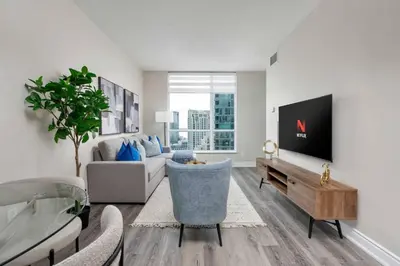 a living room with a couch and a tv at Stylish Fort York Condo w Patio Prime Location in Toronto