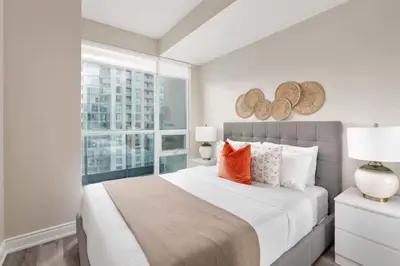 a bedroom with a large bed and a window at Stylish Fort York Condo w Patio Prime Location in Toronto