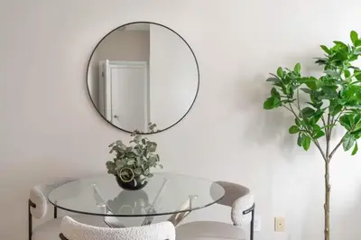 a glass table with a mirror on a white wall at Stylish Fort York Condo w Patio Prime Location in Toronto