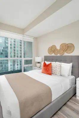 a bedroom with a large bed and a window at Stylish Fort York Condo w Patio Prime Location in Toronto