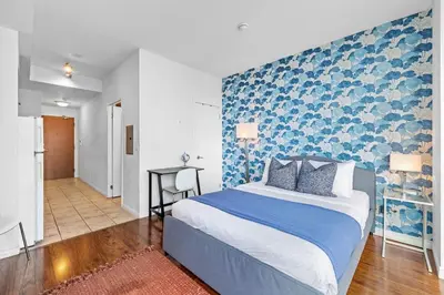 a bedroom with a bed and a blue wall at Chic Fort York Studio Cozy Retreat in Downtown in Toronto