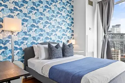 a bedroom with a bed with a blue and white wallpaper at Chic Fort York Studio Cozy Retreat in Downtown in Toronto