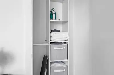 a closet with white shelves and towels at Chic Fort York Studio Cozy Retreat in Downtown in Toronto