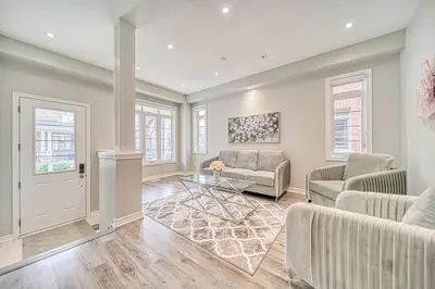 a living room with a couch and a table at Spacious 3BR Townhome Near Casino & Thermea Spa in Ajax