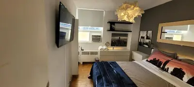 a bedroom with a bed and a television on the wall at Medium size room for 2 in Toronto