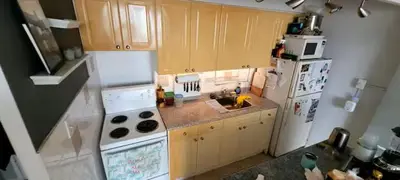 a kitchen with a white refrigerator and a sink at Medium size room for 2 in Toronto