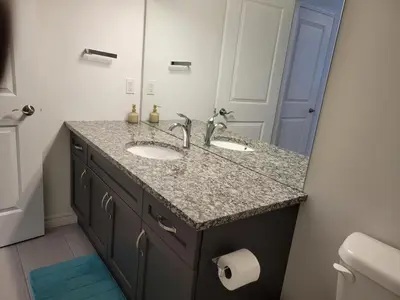 a bathroom with a sink and a mirror at Newly constructed 3-Bedroom-Hyde Park- close to UWO and Hospital in London