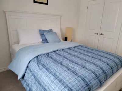 a bedroom with a bed with a blue plaid blanket at Newly constructed 3-Bedroom-Hyde Park- close to UWO and Hospital in London