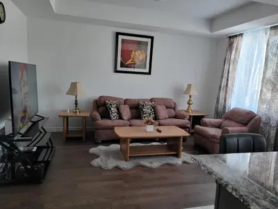 a living room with a couch and a table at Newly constructed 3-Bedroom-Hyde Park- close to UWO and Hospital in London