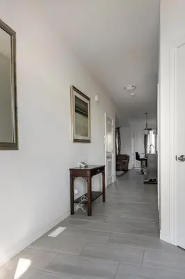 a hallway with a table and a white wall at Newly constructed 3-Bedroom-Hyde Park- close to UWO and Hospital in London
