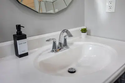 a white bathroom sink with a soap dispenser on it at Entire Unit - Steps From History - 5 Mins To Beaches in Toronto