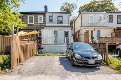a car parked in a driveway in front of a house at Entire Unit - Steps From History - 5 Mins To Beaches in Toronto
