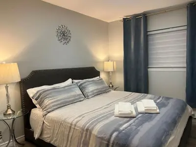a bedroom with a bed with two towels on it at Modern 2 bedroom, 2 king beds, close to Hwy in Kitchener