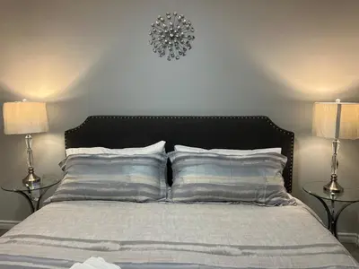a bedroom with a bed with pillows and two lamps at Modern 2 bedroom, 2 king beds, close to Hwy in Kitchener