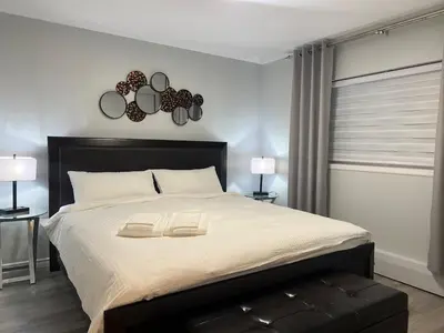 a bedroom with a large bed with two mirrors on the wall at Modern 2 bedroom, 2 king beds, close to Hwy in Kitchener