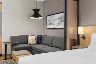 a living room with a couch and a bed at Hyatt Place Toronto Airport in Toronto
