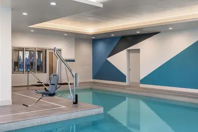 a swimming pool with a chair in a building at Hyatt Place Toronto Airport in Toronto