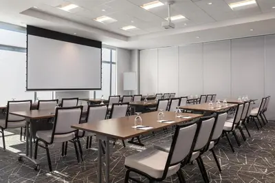 a conference room with tables and chairs and a projection screen at Hyatt Place Toronto Airport in Toronto