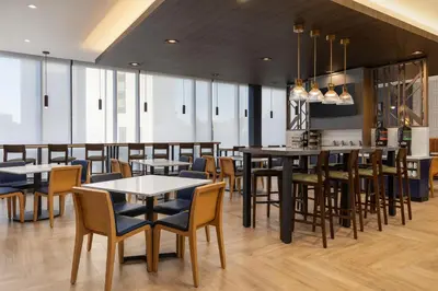 a restaurant with tables and chairs and a bar at Hyatt Place Toronto Airport in Toronto