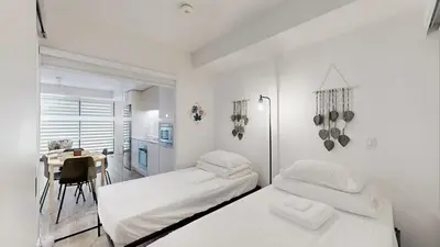 a white room with two beds and a table at Cozy 2 Bdrm 2 Bath Entire Suite - Centre Hamilton in Hamilton