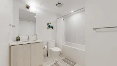 a bathroom with a toilet and a sink and a shower at Cozy 2 Bdrm 2 Bath Entire Suite - Centre Hamilton in Hamilton