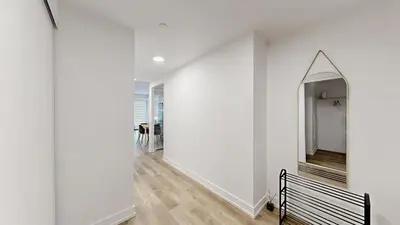 a hallway with white walls and a mirror at Cozy 2 Bdrm 2 Bath Entire Suite - Centre Hamilton in Hamilton