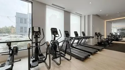 a gym with treadmills and exercise bikes in a room at Cozy 2 Bdrm 2 Bath Entire Suite - Centre Hamilton in Hamilton