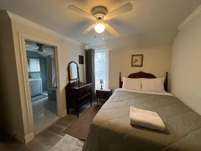 a bedroom with a bed with a ceiling fan and a mirror at Carlton House in Toronto