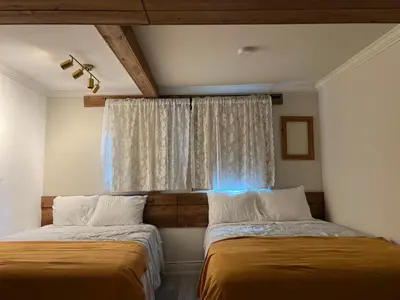 two beds sitting next to each other in a room at Carlton House in Toronto