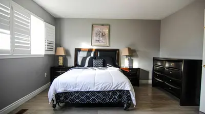 a bedroom with a bed and two dressers at Spacious 5br Home W Parking In Mississauga in Mississauga