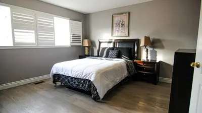 a bedroom with a bed and a window with white shutters at Spacious 5br Home W Parking In Mississauga in Mississauga