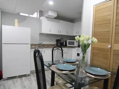 a kitchen with a dining table and a white refrigerator at Spacious 5br Home W Parking In Mississauga in Mississauga