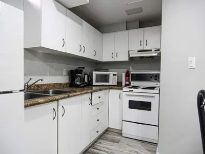 a white kitchen with white cabinets and appliances at Spacious 5br Home W Parking In Mississauga in Mississauga