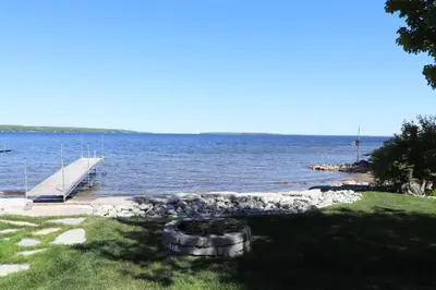 a dock with a boat in the water at Waterfront 3 Bedroom Home in Port McNicoll