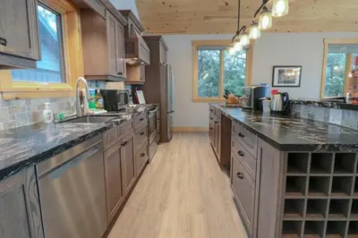 a large kitchen with wooden cabinets and granite counter tops at Waterfront 3 Bedroom Home in Port McNicoll