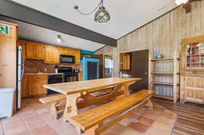 a kitchen with a wooden table and a bench at Stunning Mountain Getaway with Open Concept Design in Blue Mountains
