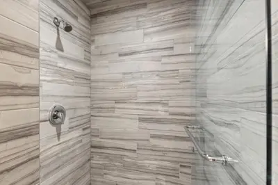 a bathroom with a shower with a glass door at 8 BR Luxury Swiss Style Chalet w Hot Tub in Blue Mountains