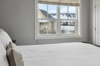 a bedroom with a white bed and a window at The 19th Hole at Blue with Hot Tub in Blue Mountains