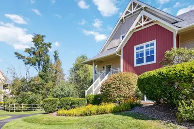 a red house with bushes in the yard at The 19th Hole at Blue with Hot Tub in Blue Mountains