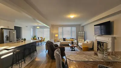 a living room with a kitchen and a living room with a fireplace at Grand Woodstock Luxe House 4BR in Woodstock