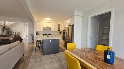 a kitchen and living room with a table and yellow chairs at Grand Woodstock Luxe House 4BR in Woodstock