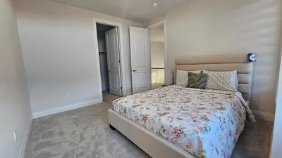 a bedroom with a bed with a floral comforter at Grand Woodstock Luxe House 4BR in Woodstock