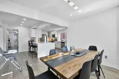 a dining room and kitchen with a table and chairs at Luxe 4BR Retreat w Heated Pool Hot Tub and BBQ in Whitby