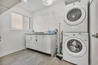 a white laundry room with a washer and dryer at Luxe 4BR Retreat w Heated Pool Hot Tub and BBQ in Whitby