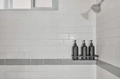 three bottles sitting on a shelf in a bathroom at Chic and Bright 1BR Apt with Free Wifi and Parking in Whitby