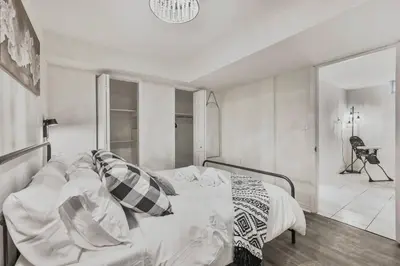 a bedroom with a bed with white sheets and pillows at Chic and Bright 1BR Apt with Free Wifi and Parking in Whitby